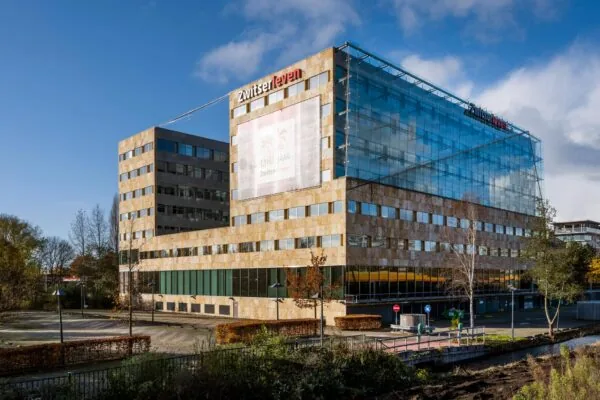 Kantoorgebouw van Zwitserleven aan de Burgemeester Rijnderslaan in Amstelveen, met een moderne glazen gevel en omliggend terrein.